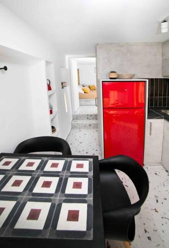 a kitchen with a table and two chairs and a red refrigerator at Cocoloco apartment in Kalymnos