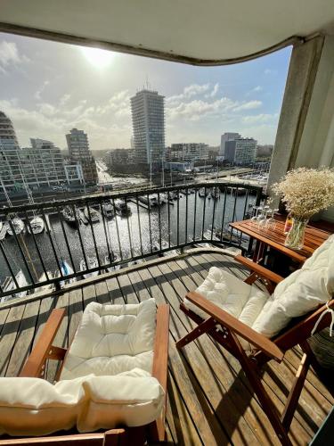 balkon z krzesłami i widokiem na rzekę w obiekcie Maison Beaufort - uniek zicht op de jachthaven w Ostendzie