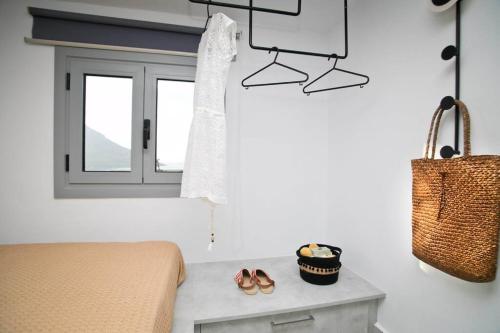 a bedroom with a bed and a window and shoes at Cocoloco apartment in Kalymnos