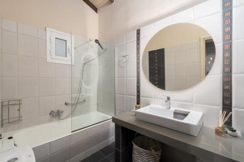uma casa de banho com um lavatório, um espelho e uma banheira em Meltemi Beach House - a seaside Luxury maisonnette em Dhiyeliótika