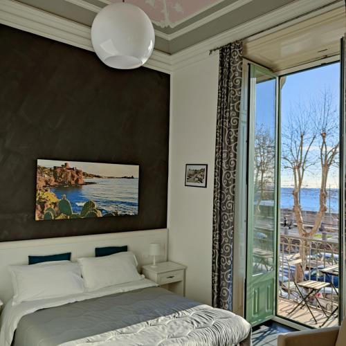a bedroom with a bed and a large window at B&B I Puritani in Catania