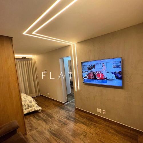 a living room with a flat screen tv on a wall at flat em são vicente in São Vicente
