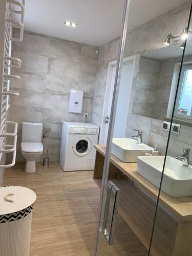 a bathroom with two sinks and a washing machine at Domek Maciej in Kopalino