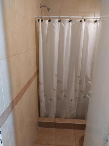y baño con ducha con cortina blanca. en Departamento G Cruz - Talca 1 con cochera en Godoy Cruz
