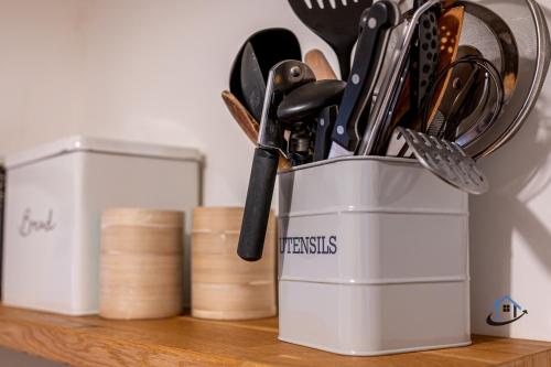 a can of utensils sitting on a wooden shelf at The Old Plough, mix of 1 bed and 3 bed units, rustic charm, super king bed or twins, en-suite, secure parking in Caldecott