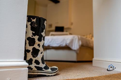 a pair of rain boots in a room with a bed at The Old Plough, mix of 1 bed and 3 bed units, rustic charm, super king bed or twins, en-suite, secure parking in Caldecott