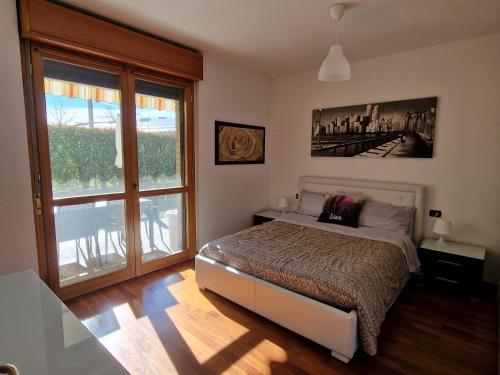 a bedroom with a bed and a large window at Appartamento Volta in Rho