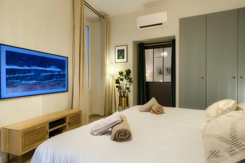 a bedroom with a white bed and a tv on the wall at CASA ALMA. Hyper Centre. Luxe. in Nice