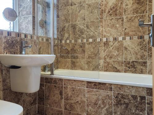 a bathroom with a sink and a toilet and a tub at City Cottage in Liberton