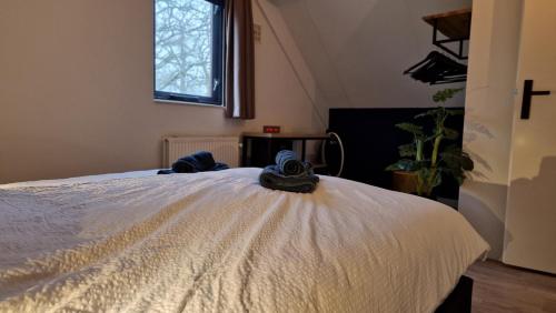 a bedroom with a bed with two hats on it at Lakeview 'Taupo' 4-6 pers by Kawatea Cottages in Ewijk