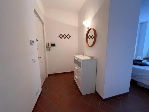 een kleine witte kamer met een bed en een dressoir bij Sandro's Home 2 in Bergamo