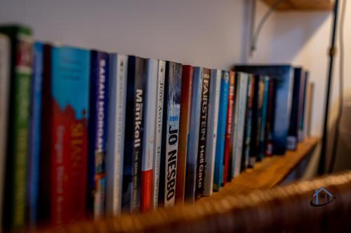 a row of books sitting on a book shelf at The Old Plough, mix of 1 bed and 3 bed units, rustic charm, super king bed or twins, en-suite, secure parking in Caldecott