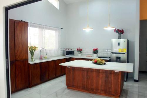 cocina con armarios de madera y encimera blanca en Cortezas House, en Aguas Zarcas