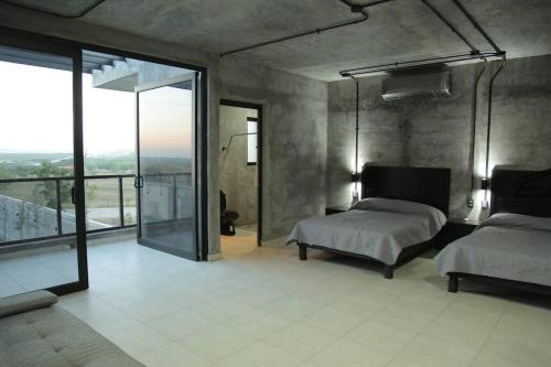 a bedroom with two beds and a large window at Casa en Allende con alberca (Casa Guaname) 