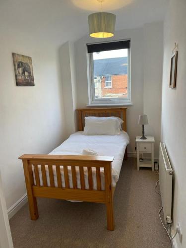 a bedroom with a wooden bed and a window at Isandula The Home from Home in Nottingham