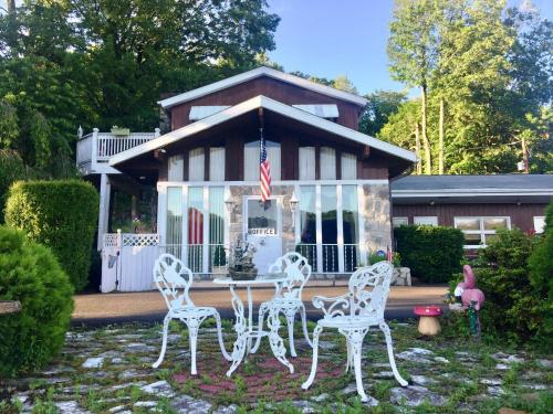 a group of white chairs in front of a house at Lake Moc A Tek Inn in Lakeville