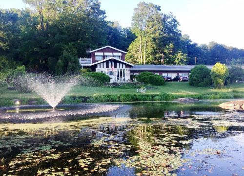 una fuente en un estanque frente a una casa en Lake Moc A Tek Inn en Lakeville