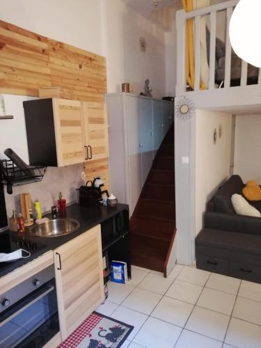une petite cuisine avec un évier et un escalier dans l'établissement Le Cocon, à Sète
