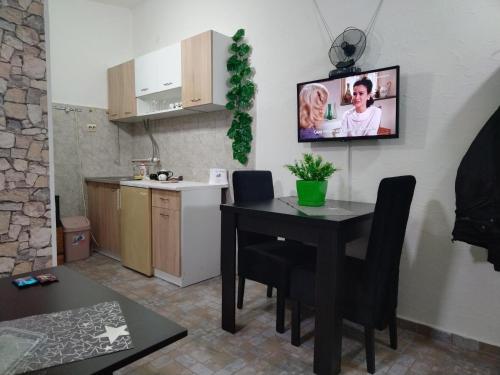 a kitchen with a table and a tv on the wall at SAN in Vranje