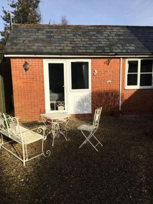 a house with two chairs and a house at The Coach House at Copper Hall in Leominster