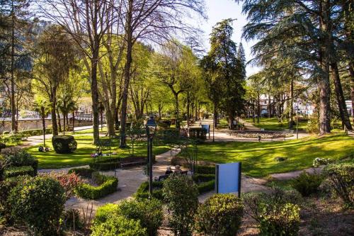 un parque con muchos árboles y arbustos en La Chaleureuse, en Vals-les-Bains