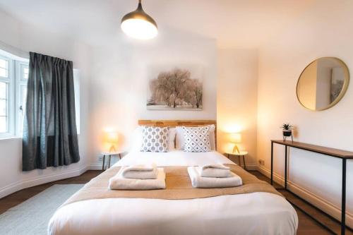 een slaapkamer met een groot bed en 2 handdoeken bij Onyx - 3 Bedroom House in Southampton