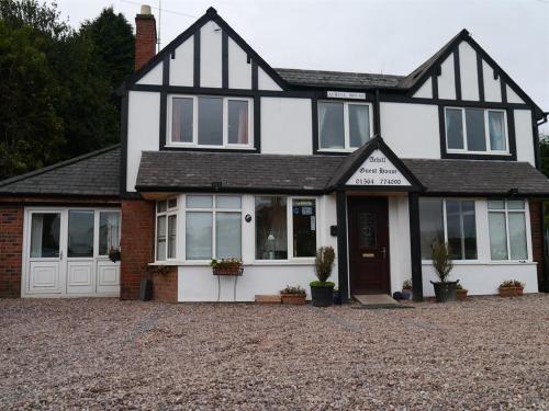 a white and black house with a driveway at Achill Guest House in Solihull