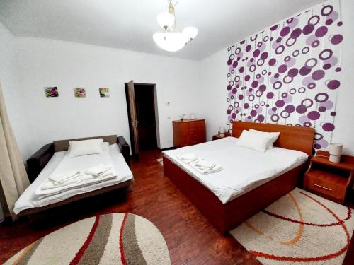 una camera con due letti e una parete viola di Casa Alex a Văliug