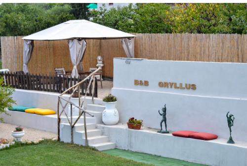 ポンペイにあるPompei Gryllusの白い傘とベンチのある庭園