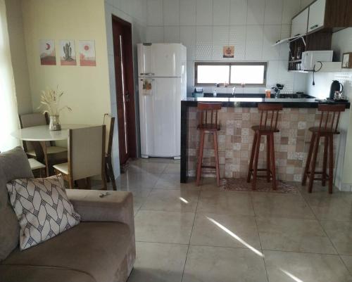 eine Küche und ein Wohnzimmer mit einem Sofa und einem Tisch in der Unterkunft Chalé Pôr do Sol in Bananeiras