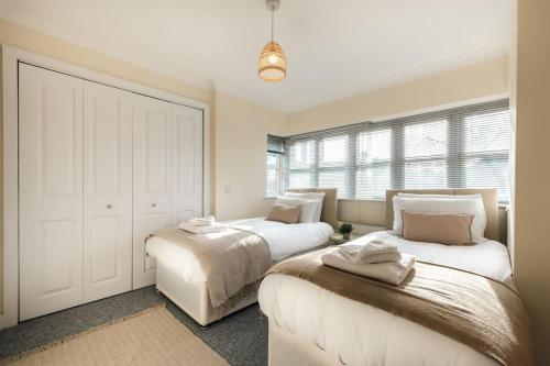 een slaapkamer met 2 bedden en een groot raam bij Azurite - 2 bedroom Flat in Southampton