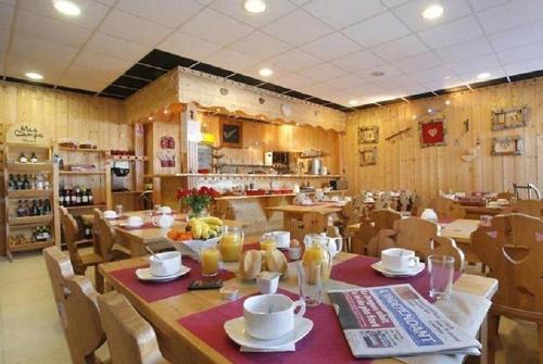 a dining room with tables and chairs and a kitchen at La Pradella Bolquere T3 PYRENEES 2000 in Bolquere Pyrenees 2000