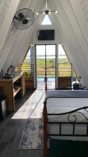a bedroom with a bed and a desk and a window at Cashaw Cabin - Private Retreat with a Pool in Treasure Beach
