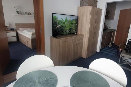 a living room with a tv and a table and chairs at Family Apartment, 2 Bedrooms, 2 Bathrooms, Bavarian Forest in Mitterfirmiansreut
