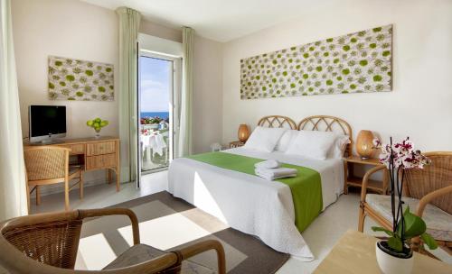 a bedroom with a bed and a balcony at Hotel Mida in Scoglitti