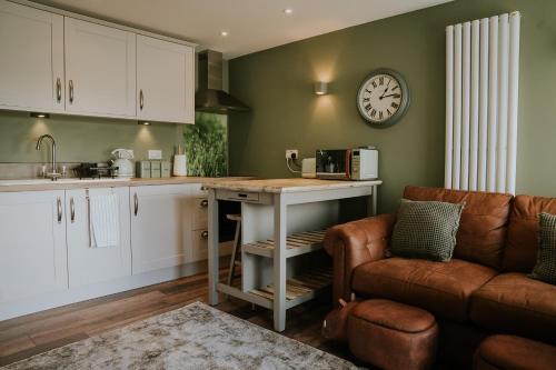 a kitchen with a table and a clock on the wall at Whiteside Granary in Haltwhistle