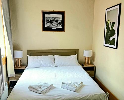 1 dormitorio con 1 cama con 2 toallas en Family Hotel, en Bathurst