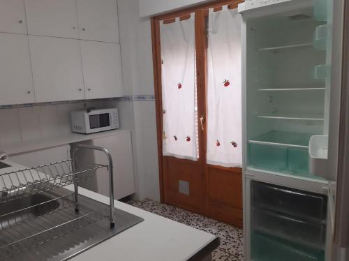 a kitchen with an empty refrigerator and a microwave at La Cruz Negra de Veruela in Vera de Moncayo