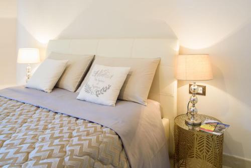 a bedroom with a bed with white sheets and pillows at HomeAway Salerno in Salerno