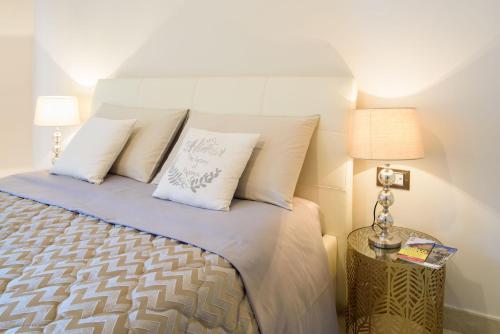 1 dormitorio con 1 cama con sábanas y almohadas blancas en HomeAway Salerno, en Salerno