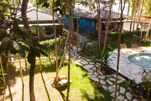 a garden with a swimming pool and a house at Vila Marina in Arraial d'Ajuda