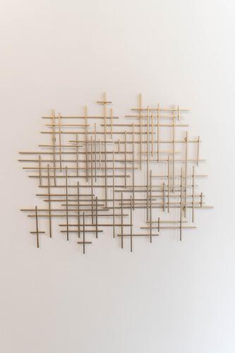 a metal sculpture hanging on a white wall at Apartamento moderno 1 habitación y 1 baño, área Cayalá Embajada USA in Guatemala
