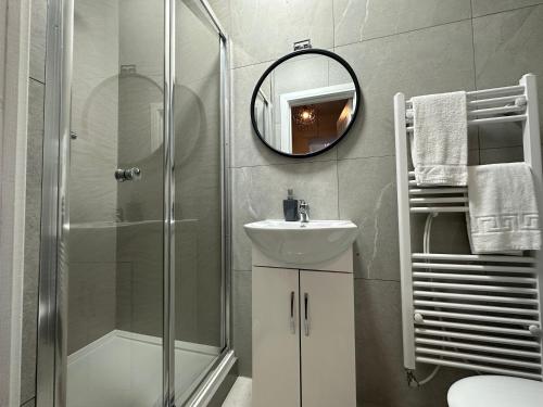 y baño con ducha, lavabo y espejo. en Nottage House Premier Apartments, en Cardiff