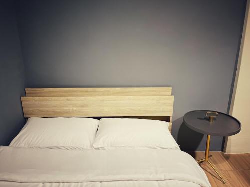 a bed with a wooden head board and a table at 東海平行陸貳民宿English Friendly in Longjing