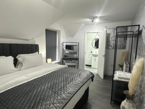 1 dormitorio con 1 cama grande y espejo en Nottage House Premier Apartments, en Cardiff