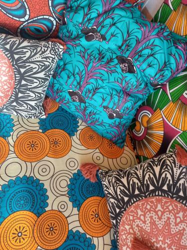 a pile of colorful pillows on a bed at Appartamento Alma de Cri 10b, Sal Rei Estoril in Sal Rei