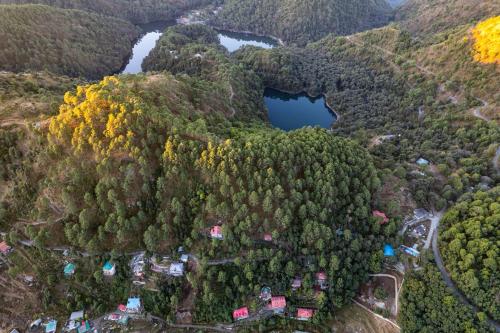 an aerial view of a forest with two lakes at The Canadian Woods Resort in Nainital