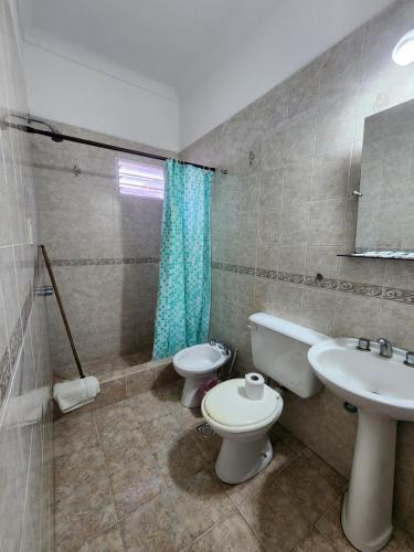 łazienka z toaletą i umywalką w obiekcie Hotel El Cisne w mieście Villa Gesell