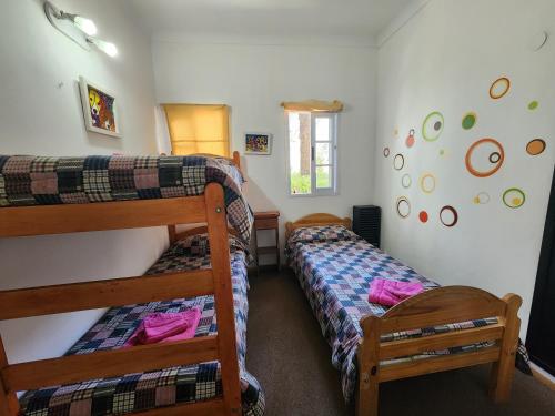 sypialnia z 2 łóżkami piętrowymi i oknem w obiekcie Hotel El Cisne w mieście Villa Gesell