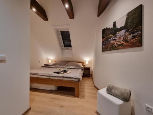 1 dormitorio con 1 cama y una pintura en la pared en Apartmán U Bašty, en Vimperk